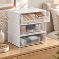 Clear stackable jewelry drawers on an oak dresser with gold jewelry in the open top drawer